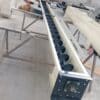 ADDAMS screw conveyor with exposed helical flight and end bearing in the workshop