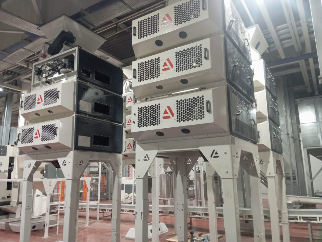 Several tall ADDAMS processing assemblies with stacked guarded modules and discharge hoppers in the workshop